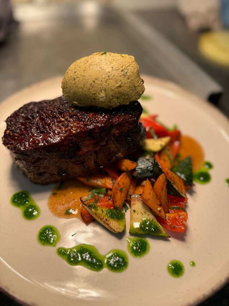 Saftig gebratenes Steak mit Kräuterbutter und Gemüse